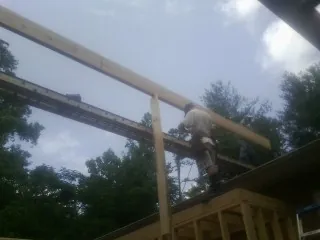 Carpenter setting a ridge beam over a new addition frame — Ice Dam Removal by Roofing Brothers in Osseo
